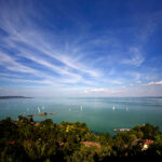 Large vertorama of Tihany’s port with sailing boats in the distance.