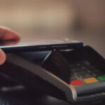 Hand with a smart phone using the terminal for payment by NFC technology