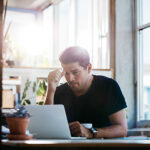 Business man thinking about a problem at his laptop